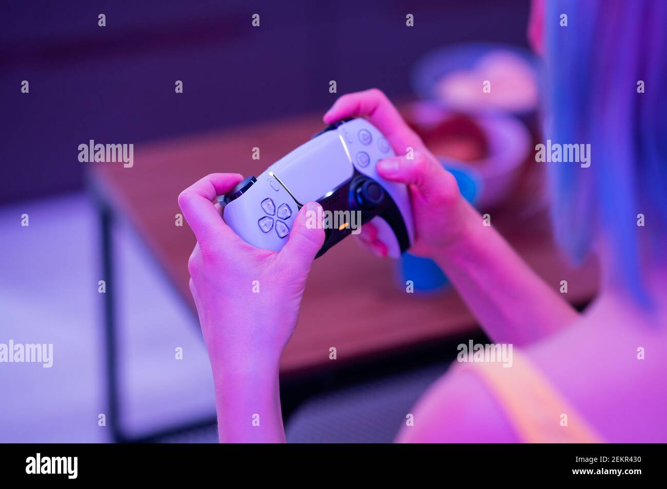 Fille avec contrôleur de prochaine génération dans ses mains jouant à des jeux à la maison. Banque D'Images