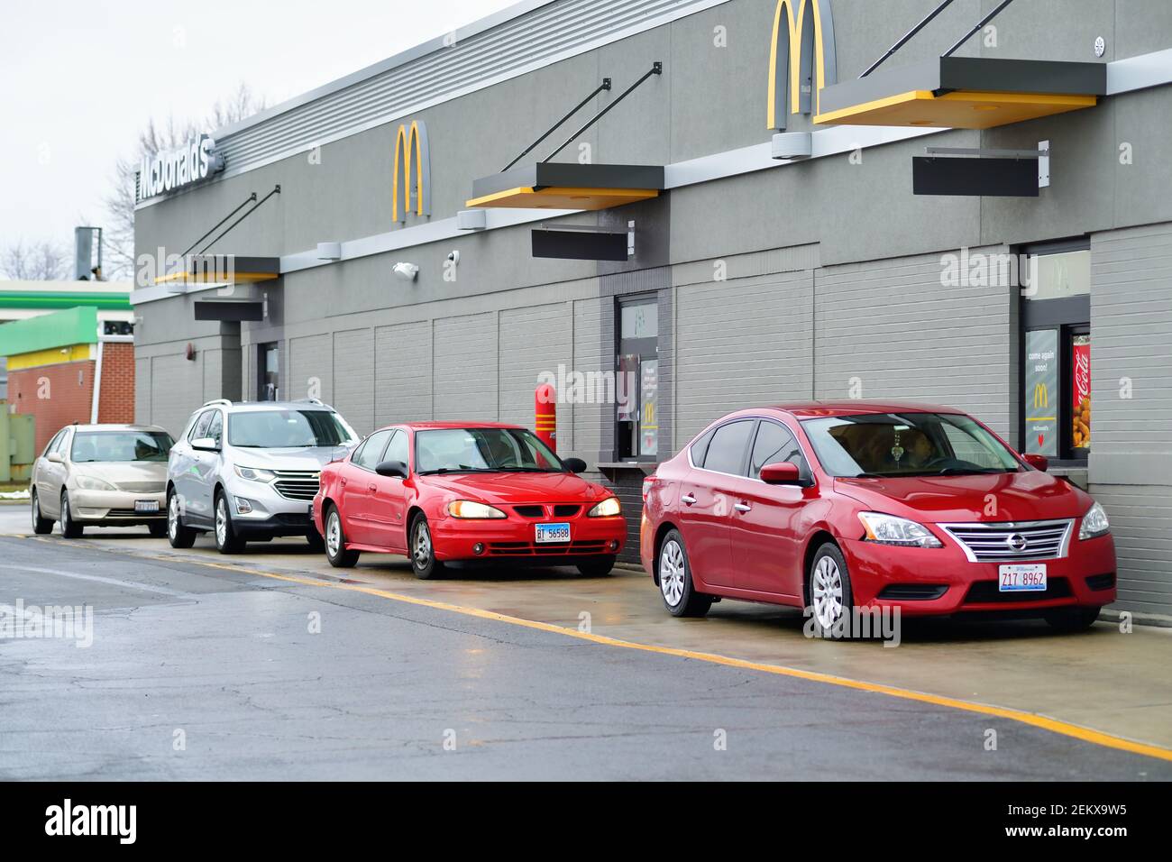 Carol Stream, Illinois, USA. Voitures alignées dans un McDonald's drive-thru restaurant dans la banlieue de Chicago. Banque D'Images