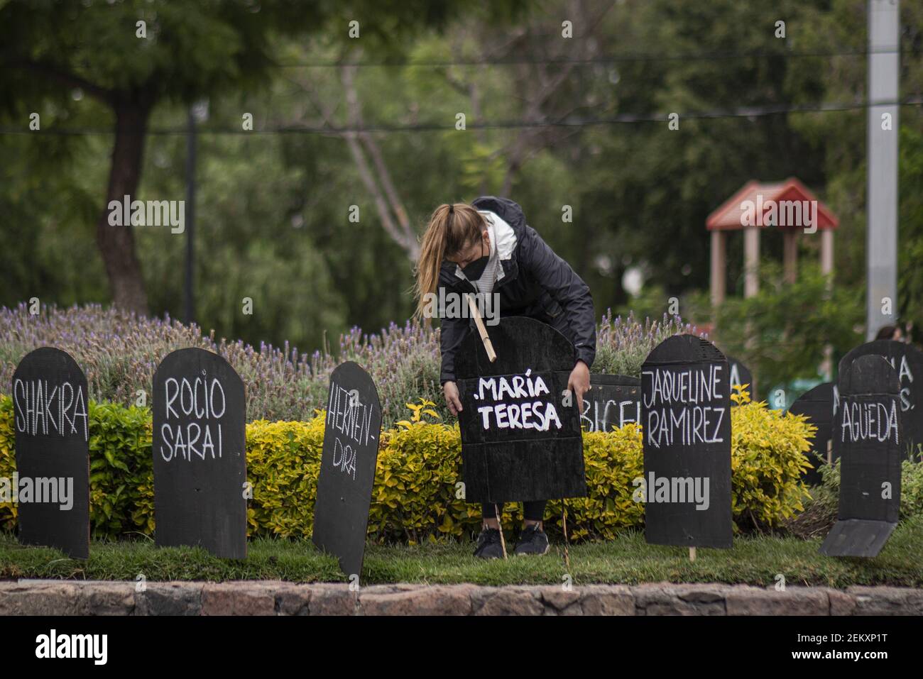 Une femme place une pierre tombale en carton à Calzada de los Arcos à la  mémoire des femmes assassinées à Querétaro. Un groupe de femmes a  symboliquement placé plus de 400 pierres