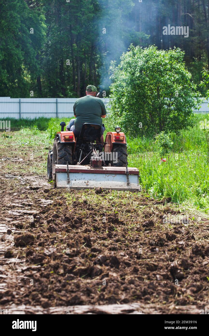 Défrichement et nivellement d'un terrain privé. Un cultivateur sur piste creuse un terrain privé Banque D'Images