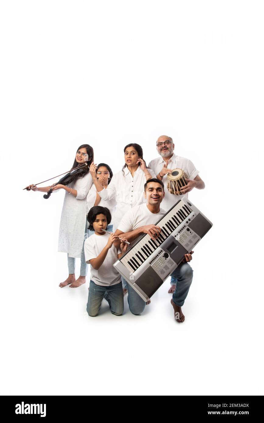 Concert d'une famille indienne de six personnes jouant des instruments de musique dans un groupe et une femme âgée chantant, debout sur fond blanc Banque D'Images