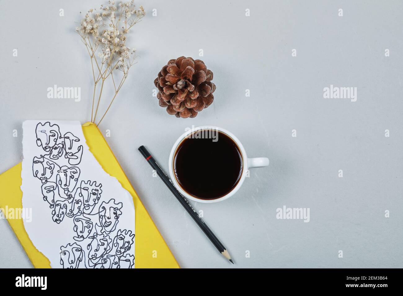Un cône forestier avec une tasse de café, un crayon, du papier de dessin et de fleur Banque D'Images