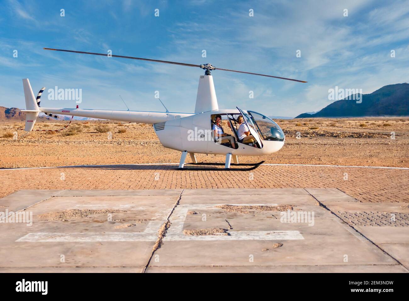 Sossusvlei, Namibie - 26 août 2016. Un hélicoptère touristique se trouve au sol tandis que le pilote se prépare à prendre un vol au-dessus du désert du Namib. Banque D'Images