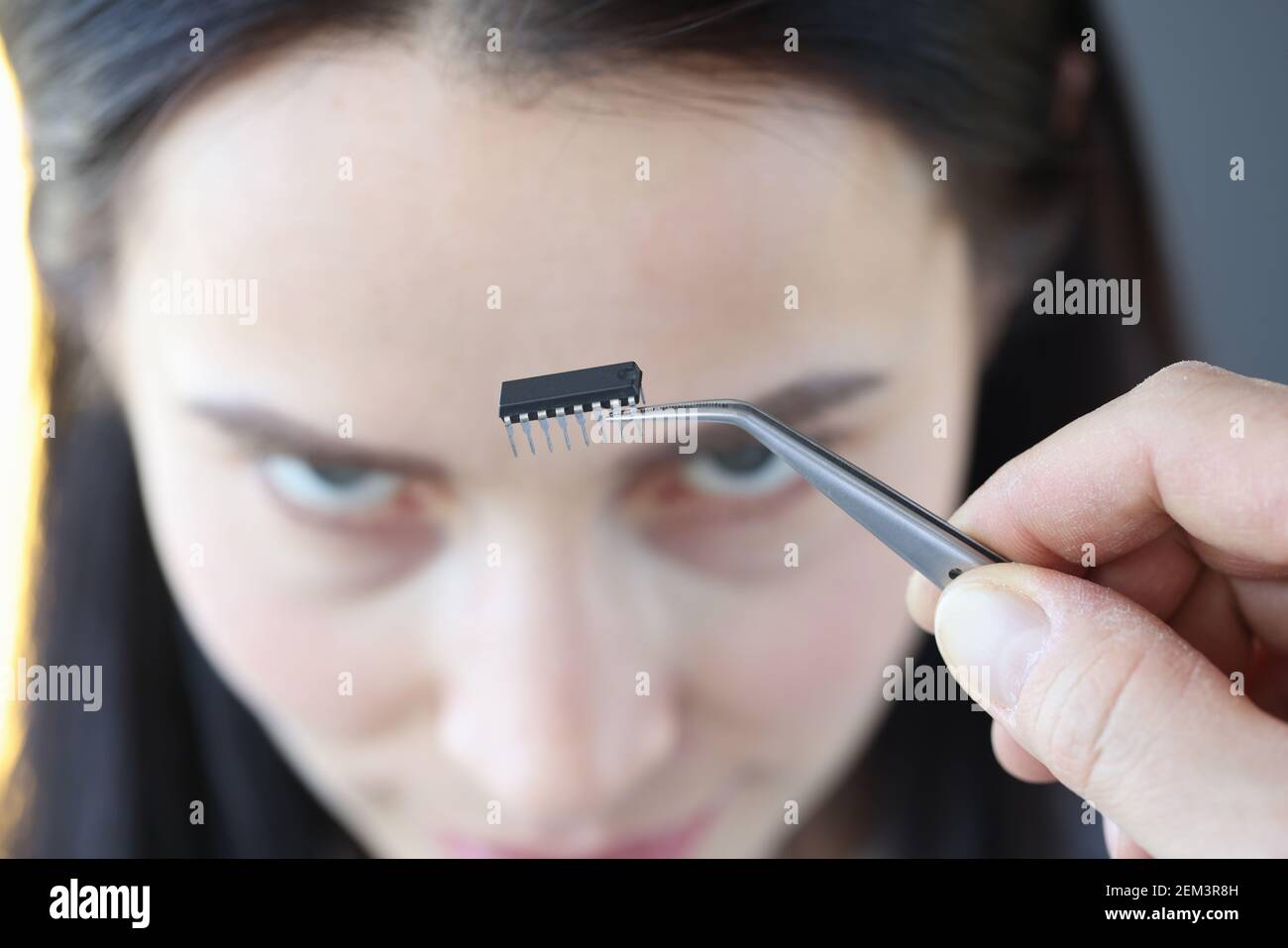 Petite puce de microcircuit devant la tête de la femme Banque D'Images