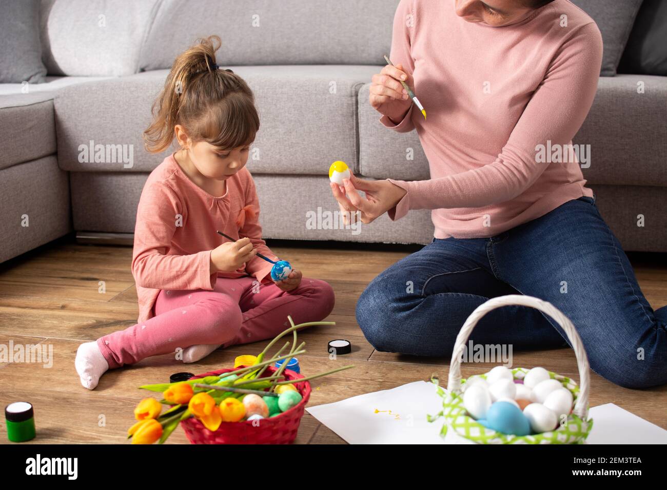 Une mère et sa fille peignant des œufs de Pâques à la maison. Banque D'Images