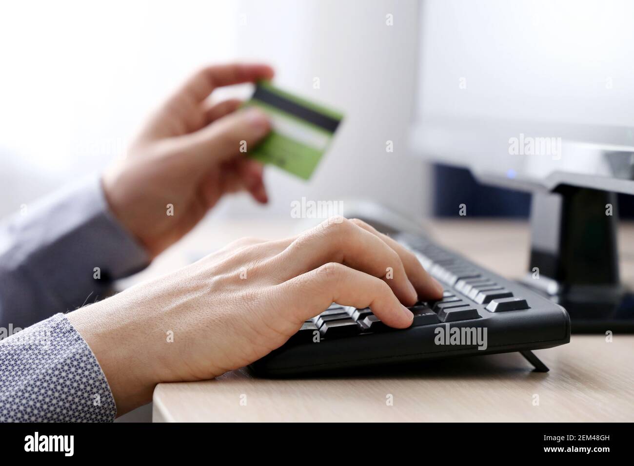 Homme tenant les types de carte de crédit de banque sur le clavier de PC. Concept d'achat et de paiement en ligne, transactions financières Banque D'Images