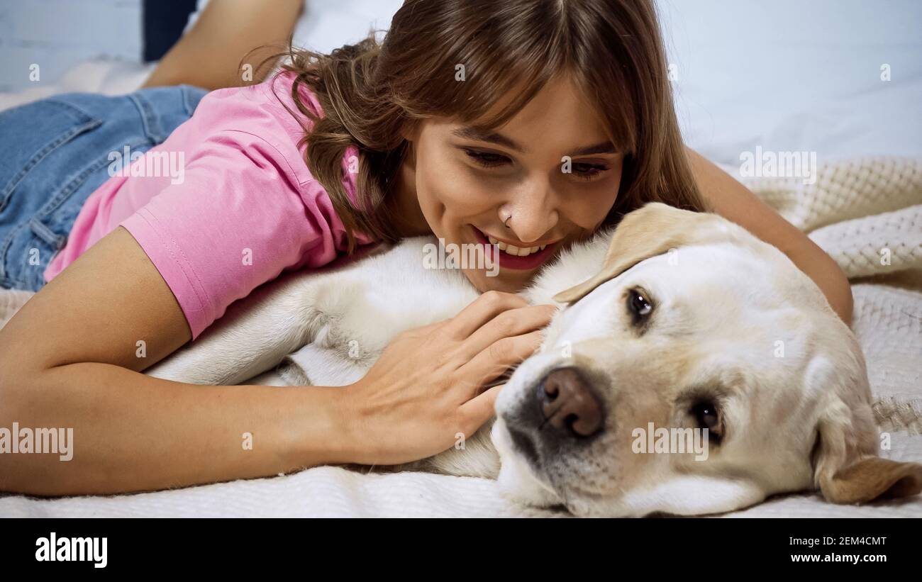 bonne jeune femme couché avec un chien d'or retriever sur le lit Photo  Stock - Alamy