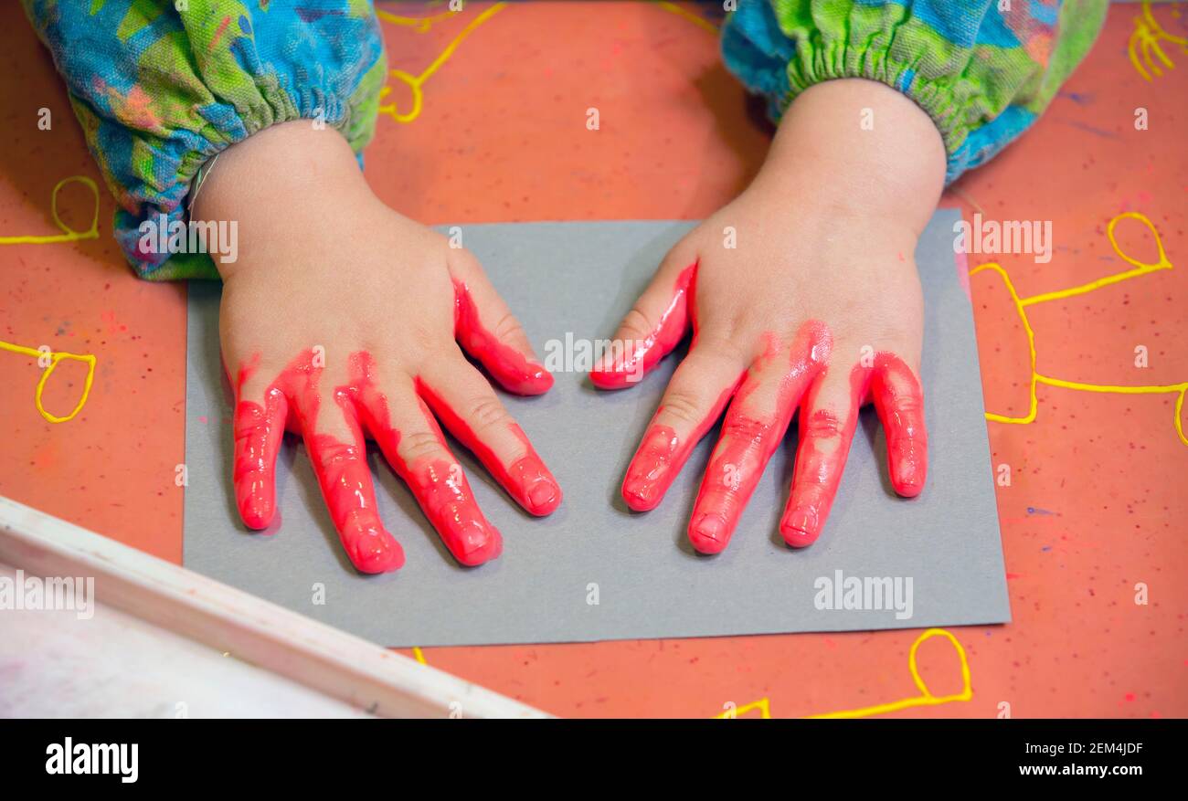Les mains d'un jeune enfant font de la peinture avec des peintures pour les doigts Banque D'Images
