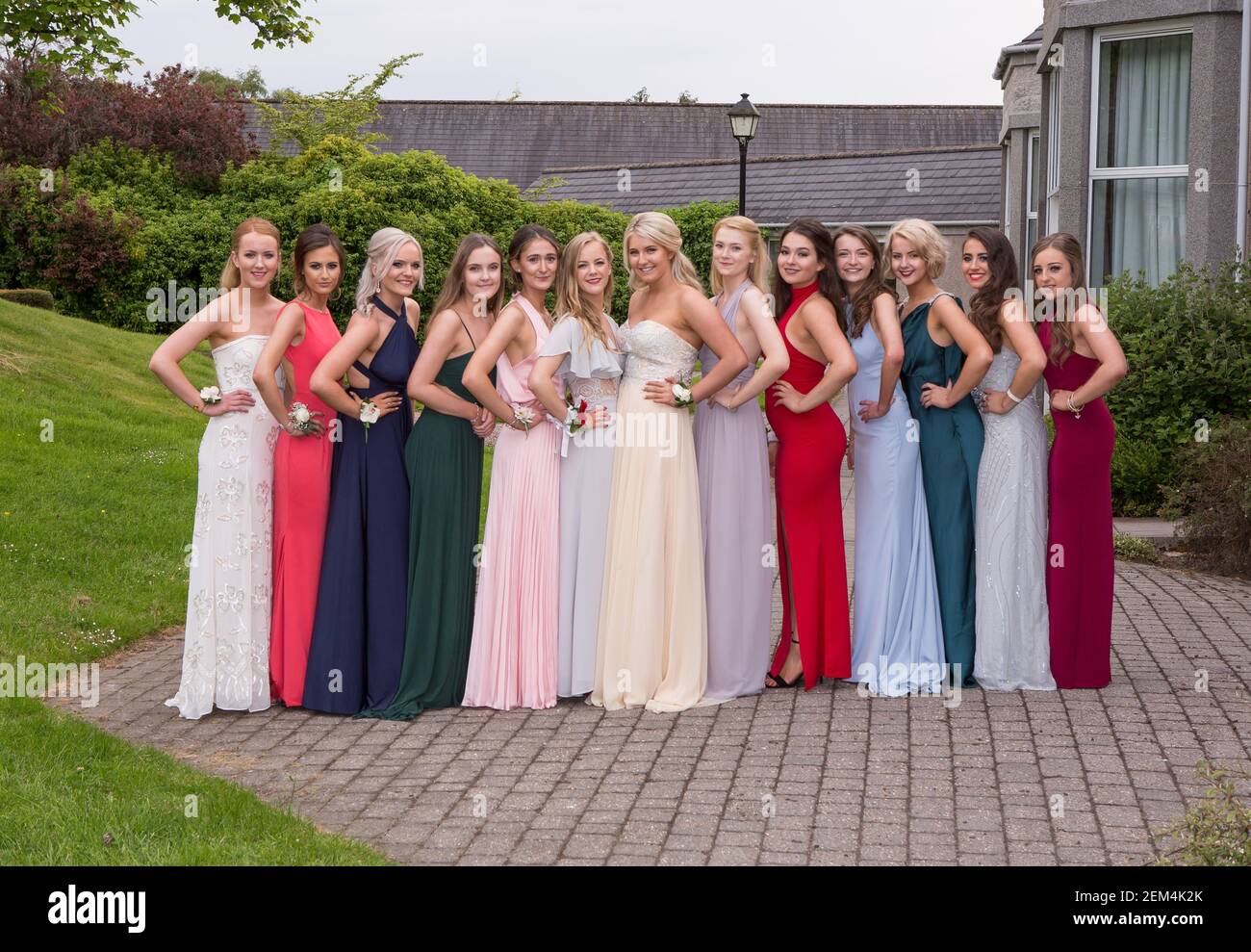 Filles ou jeunes femmes en robes pour leur fin de bal prom quand ils quittent l'école Banque D'Images