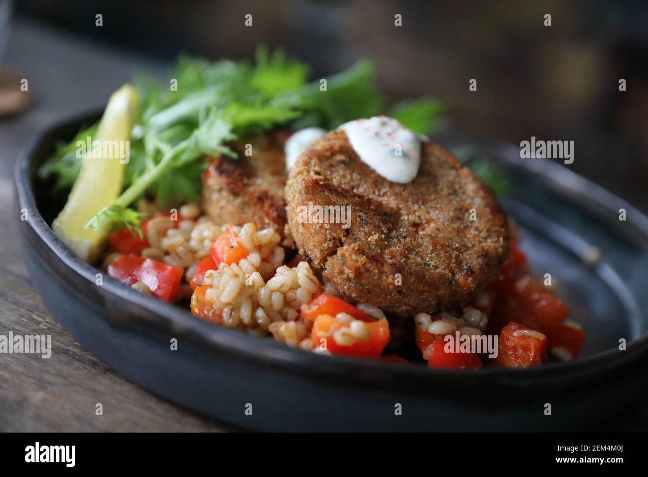 Salmon fishcakes avec salade et d'avoine sur table en bois Banque D'Images