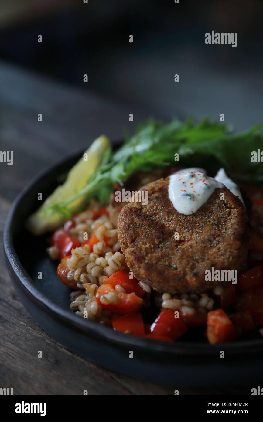 Salmon fishcakes avec salade et d'avoine sur table en bois Banque D'Images