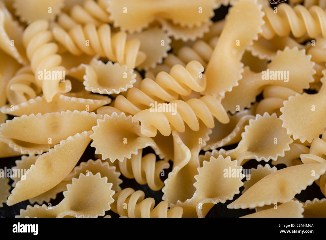 Pâtes farfalle et girandole crues sur fond noir Banque D'Images