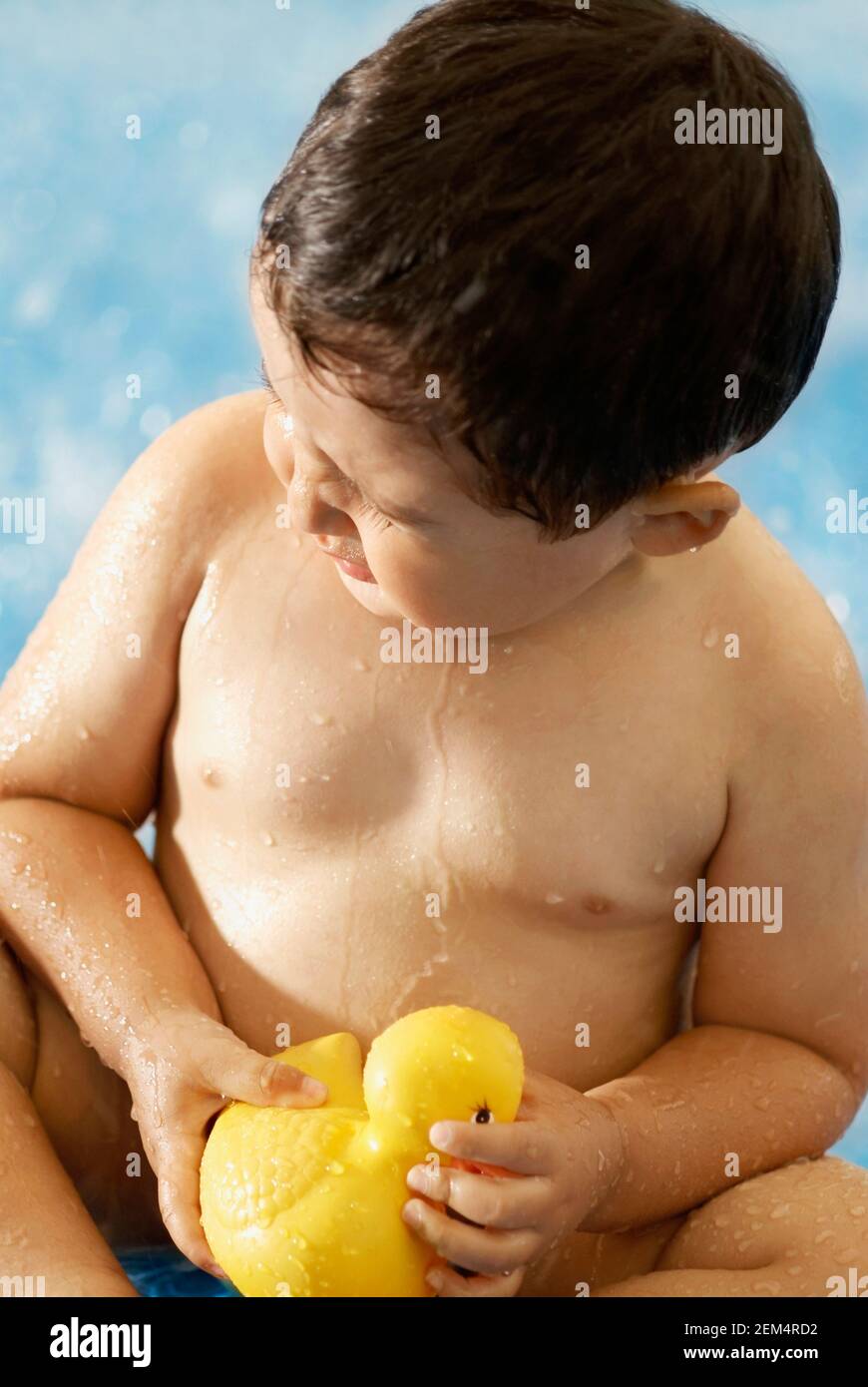 Gros plan d'un bébé garçon jouant avec un canard en caoutchouc dans une piscine Banque D'Images