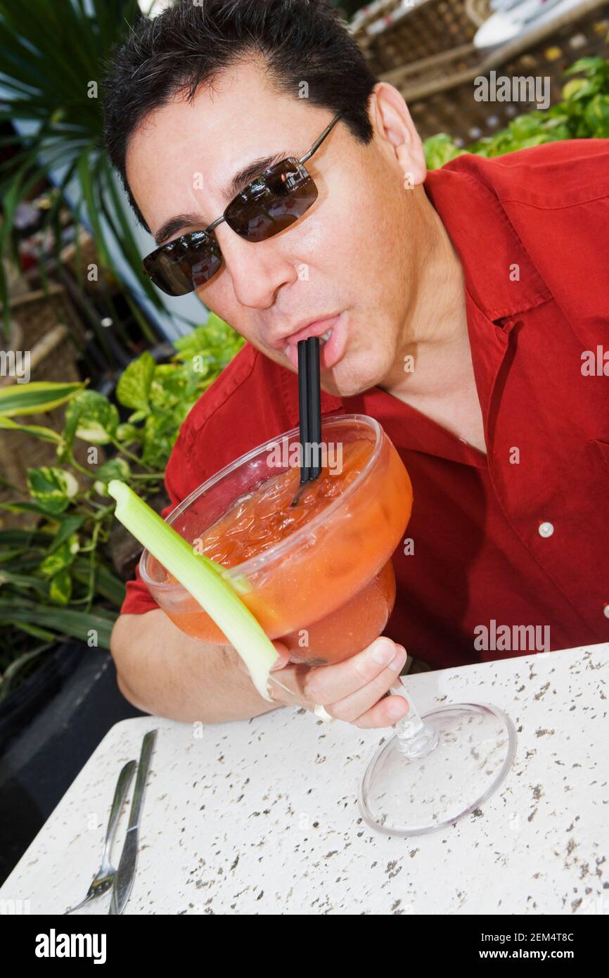 Gros plan d'un homme mature qui boit un cocktail Banque D'Images