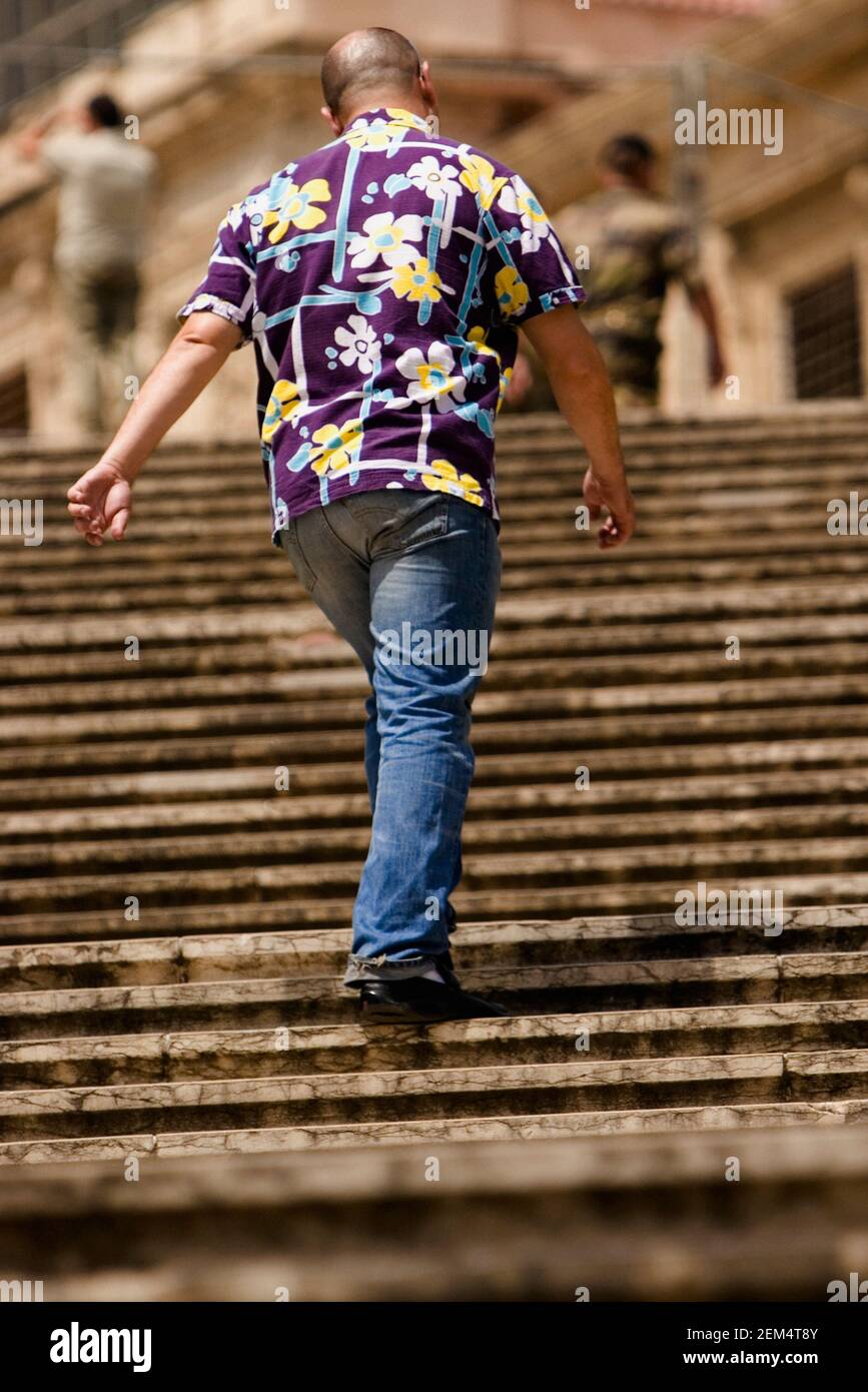 Vue arrière d'un homme qui marche dans les escaliers Banque D'Images