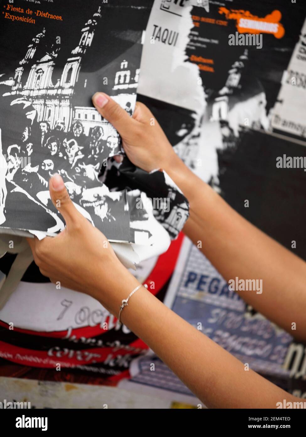 Gros plan des mains d'une femme déchirant une affiche Banque D'Images