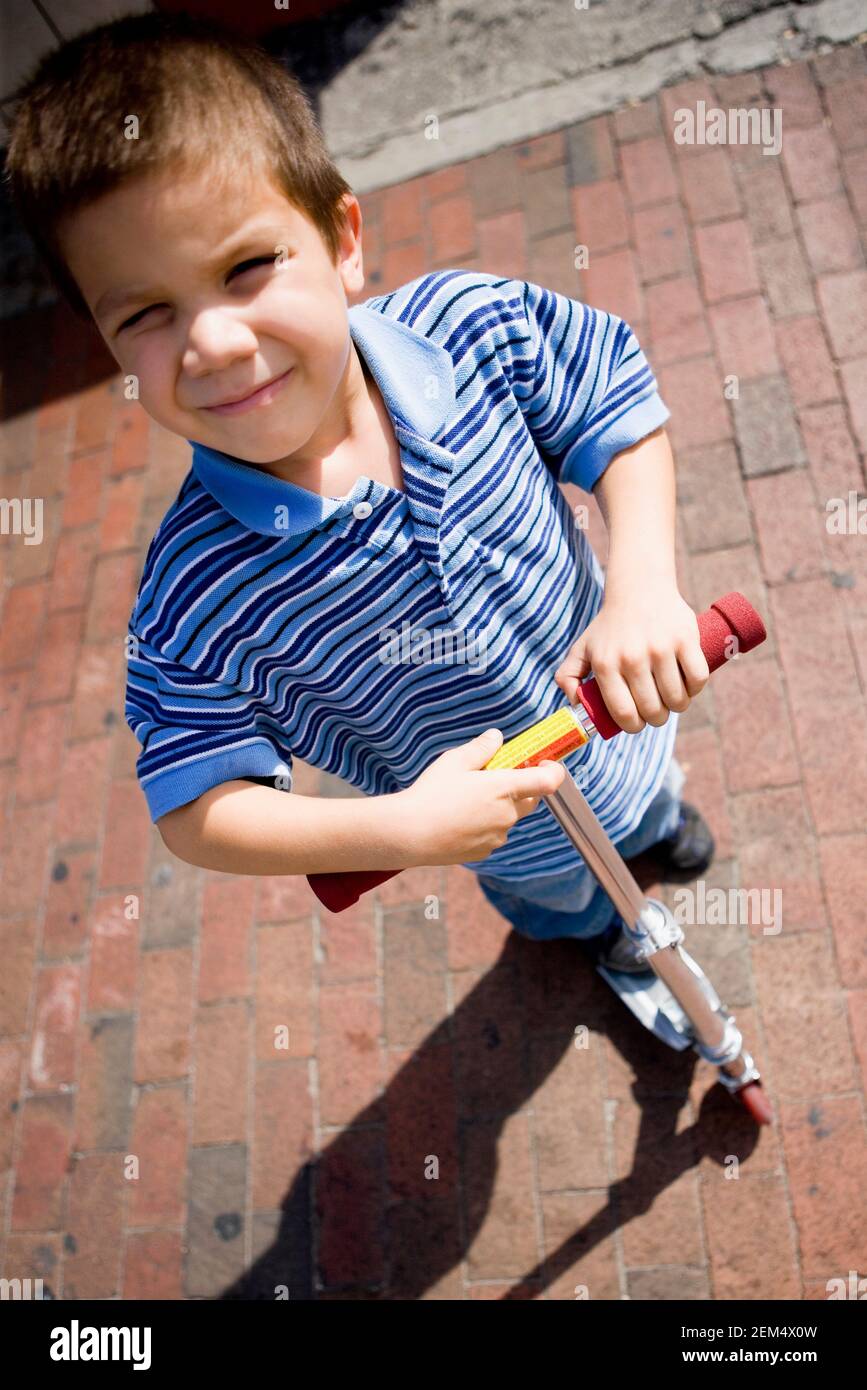 Vue en grand angle d'un garçon debout sur une poussée scooter Banque D'Images