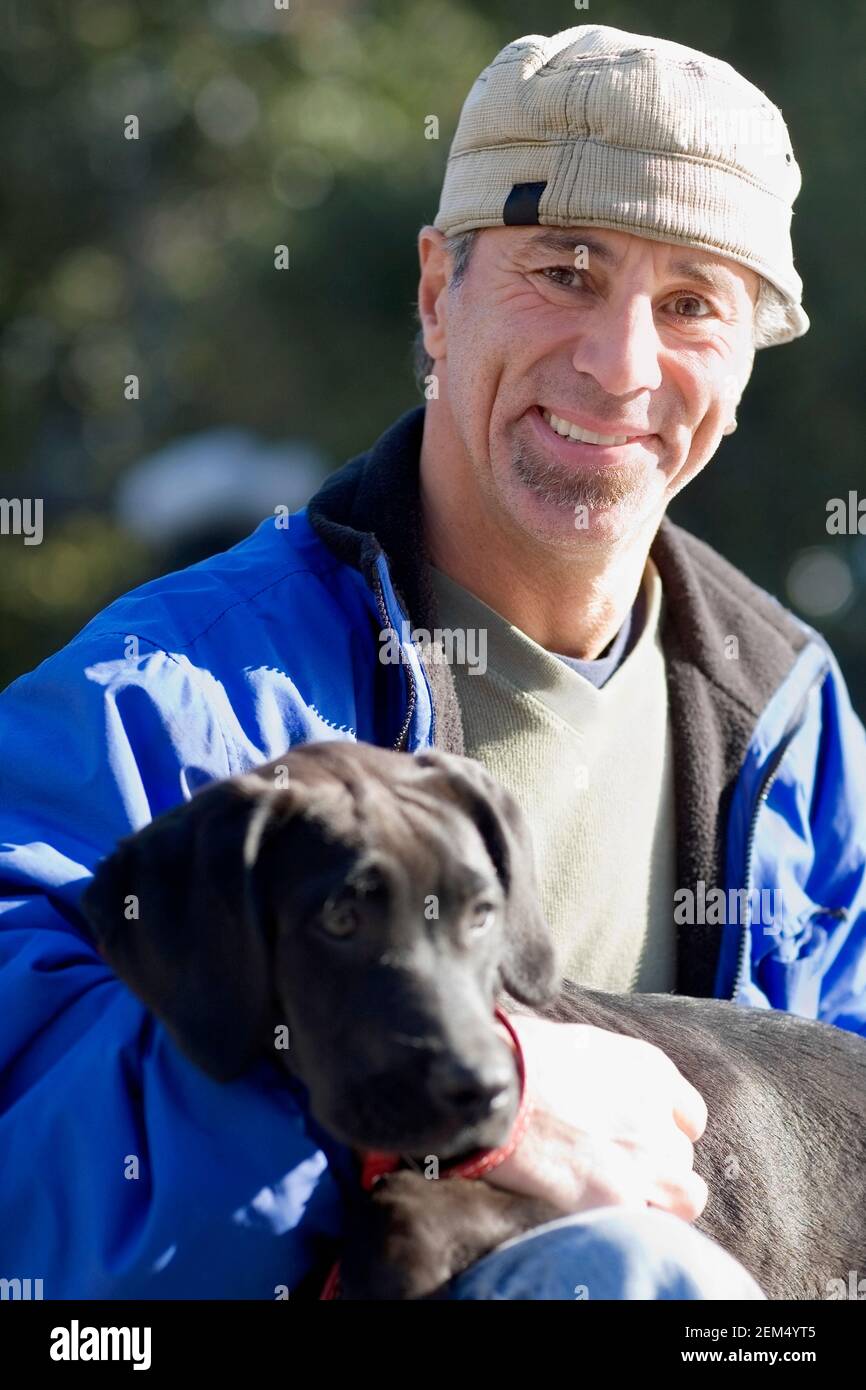 Portrait d'un homme mûr tenant son chien et souriant Banque D'Images