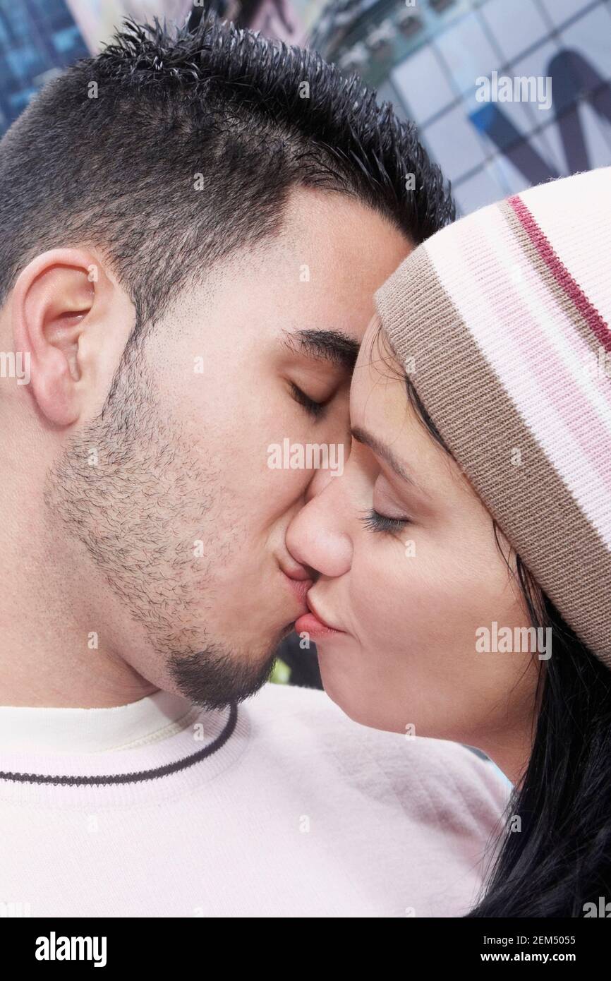Gros plan d'une femme de taille moyenne et d'un jeune homme s'embrasser Banque D'Images
