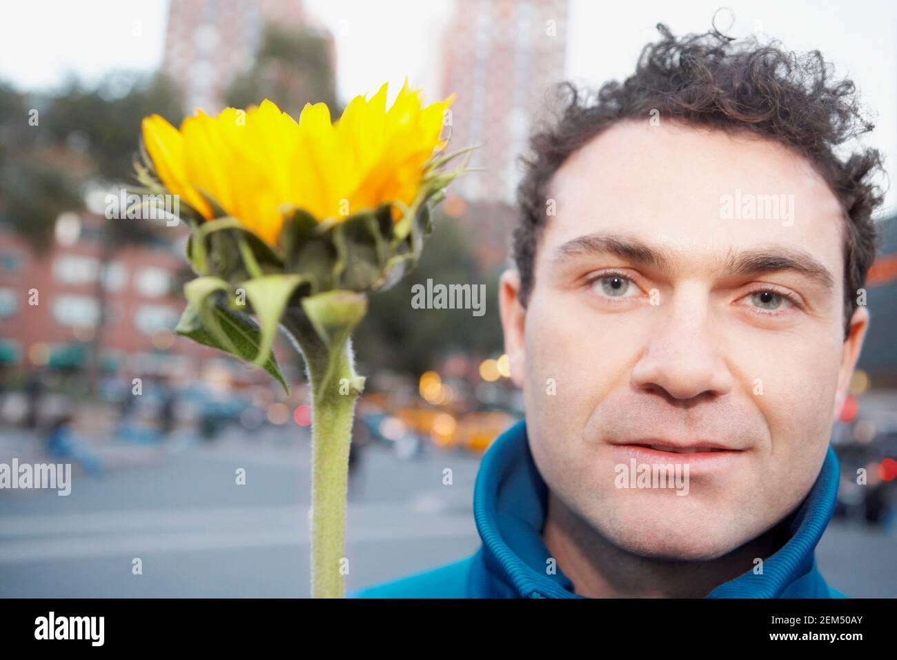 Portrait d'un jeune homme avec une fleur Banque D'Images
