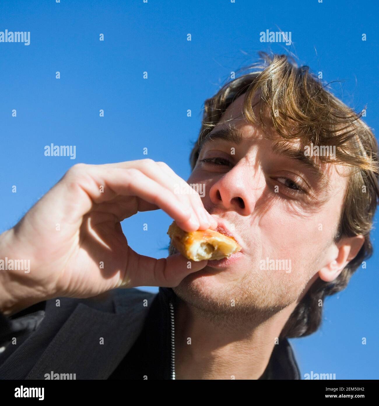 Portrait d'un jeune homme mangeant de la nourriture Banque D'Images