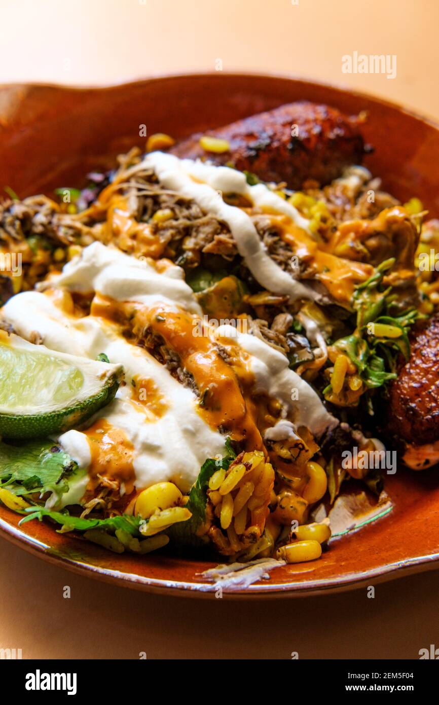 Bol de riz jamaïcain au poulet jerk avec des plantains sucrés et chauds sauce Banque D'Images