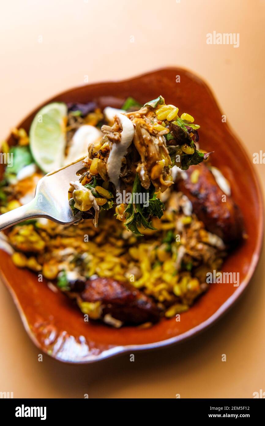 Bol de riz jamaïcain au poulet jerk avec des plantains sucrés et chauds sauce Banque D'Images