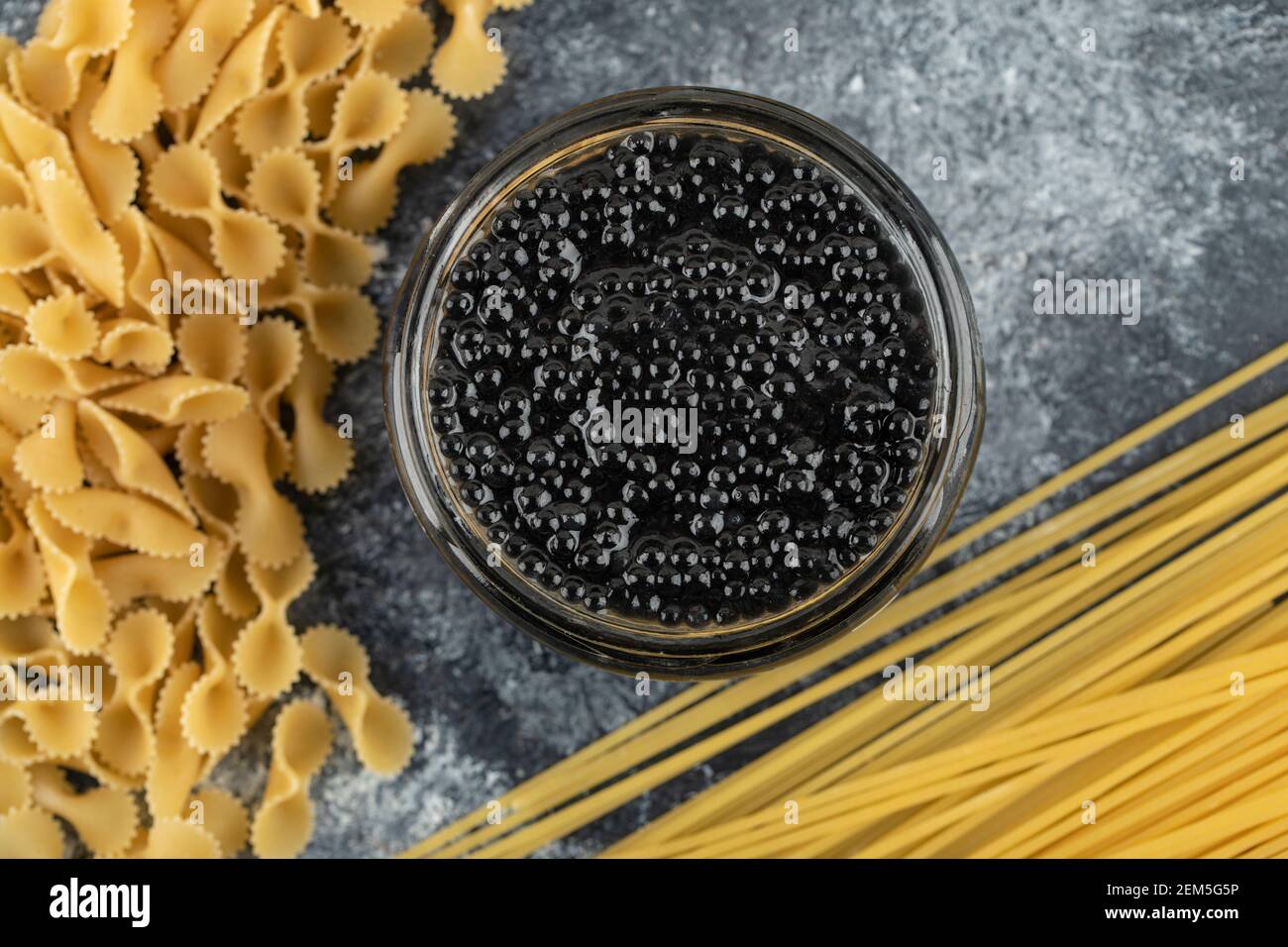 Une plaque de verre de caviar d'esturgeon noir avec des pâtes non cuites Banque D'Images