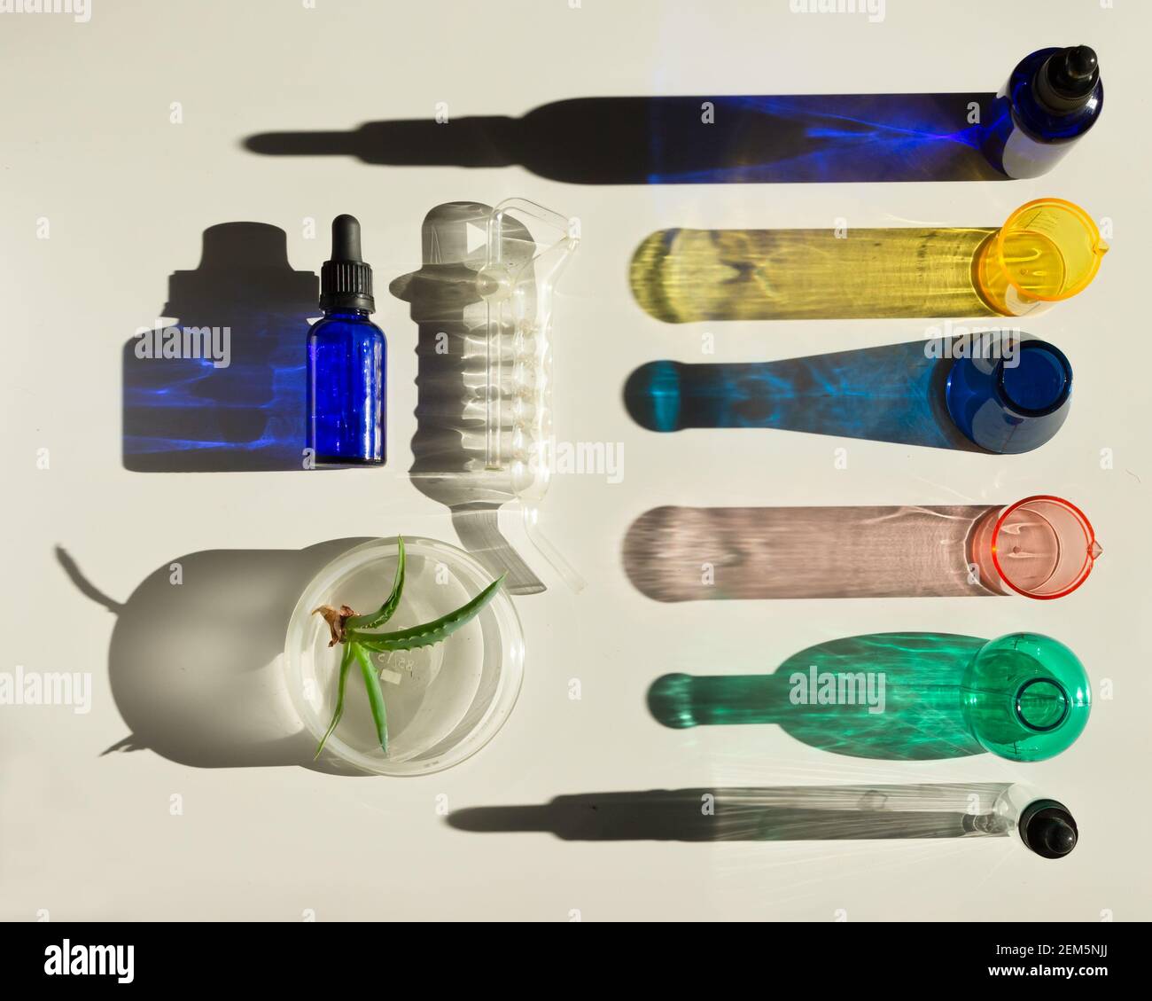 Laboratoire cosmétique ou chimique abstrait. Équipement de laboratoire, flacons, tubes à essai, boîtes de Petri. Concept créatif avec ombres dures. Banque D'Images