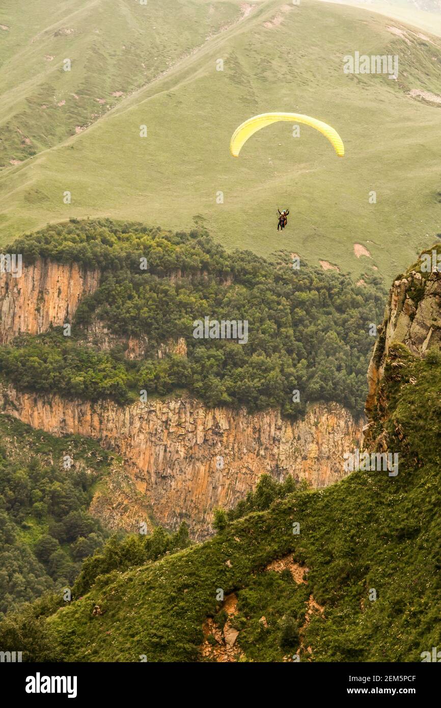 Deux parapentes volent en tandem au-dessus des montagnes et sauvages gorges des montagnes du Caucase inférieur en Géorgie Banque D'Images