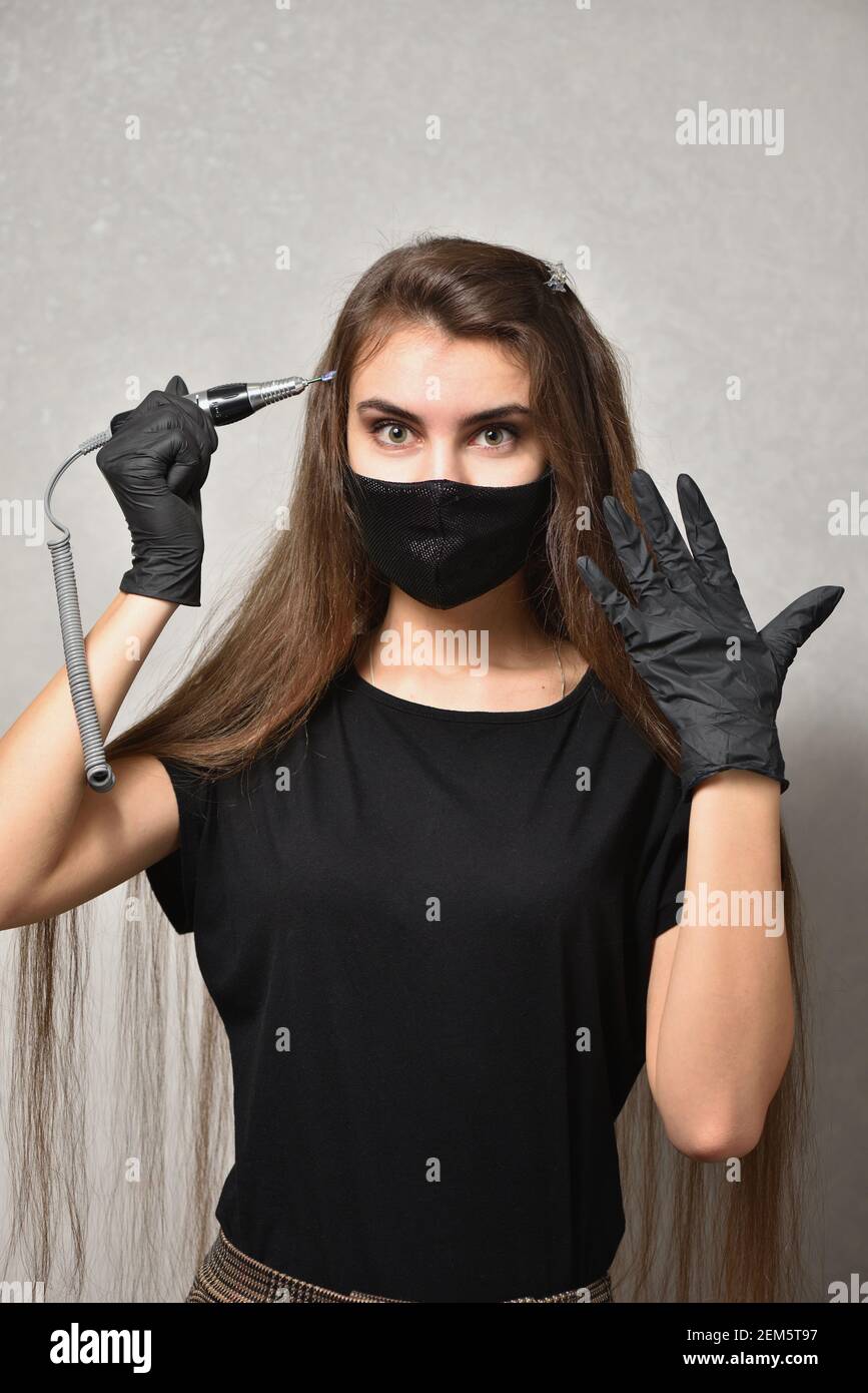 Jeune femme manucuriste posant avec lime à ongles électrique, concept de soins des ongles Banque D'Images