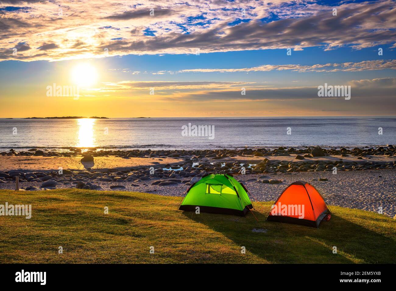 Camping au coucher du soleil avec tentes sur la plage d'Uttakleiv dans les îles Lofoten, Norvège Banque D'Images
