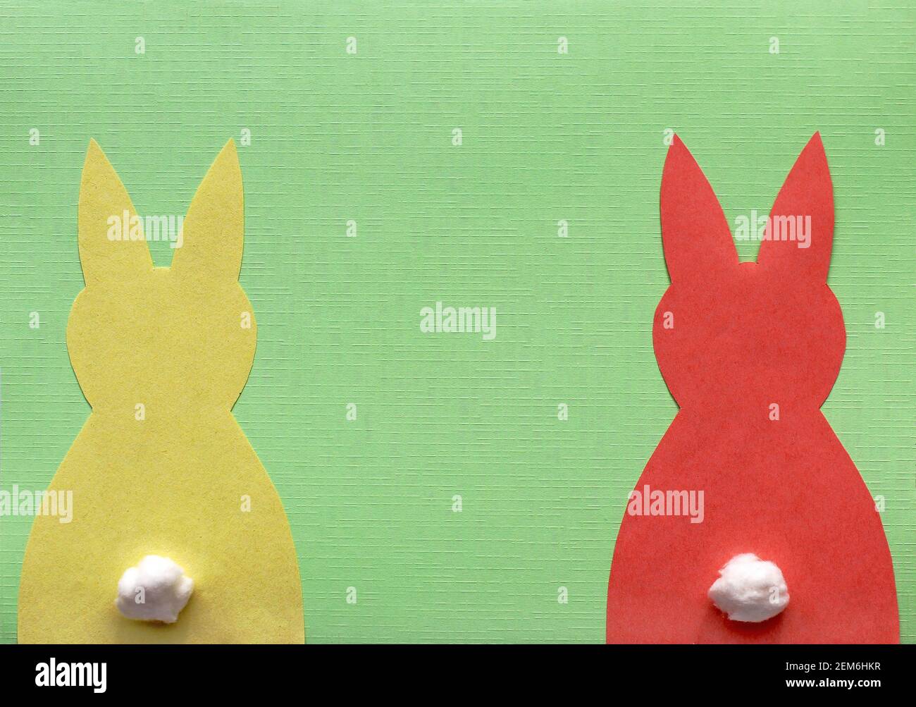 Un lapin de Pâques en papier jaune et un lapin rouge sur vert arrière-plan Banque D'Images