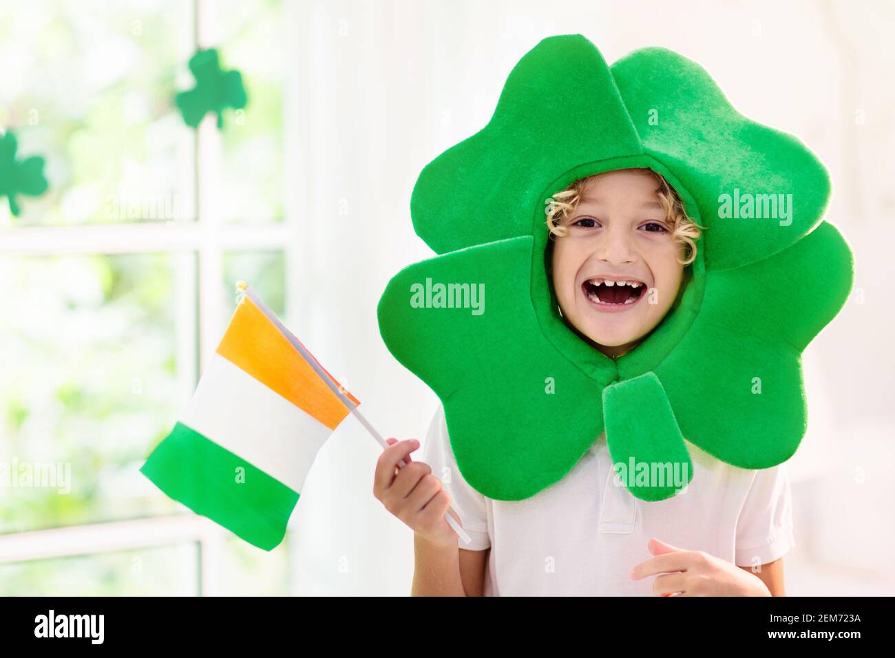 Famille célébrant la Saint-Patrick. Vacances, culture et tradition irlandaises. Les enfants portent un chapeau de lepreun vert et de la barbe avec le drapeau irlandais et la feuille de trèfle Banque D'Images