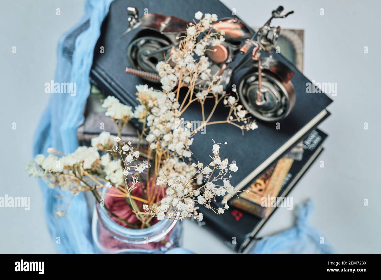 Un petit vélo avec des fleurs sur fond bleu Banque D'Images