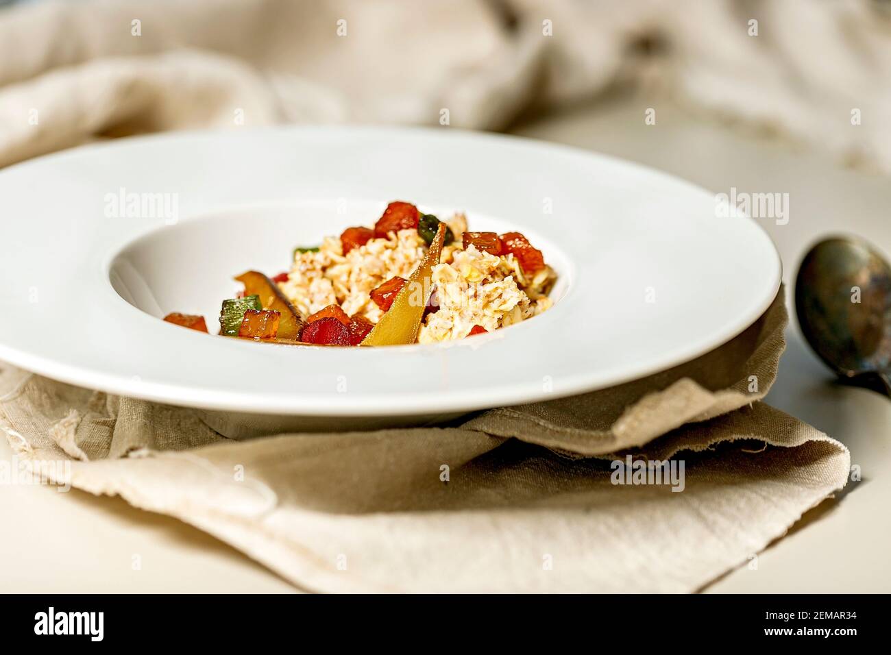 Gros plan de flocons d'avoine avec fruits sur une assiette blanche. Poire douce et fruits confits. Petit déjeuner délicieux et sain. Idées et recettes pour les repas à la maison. Banque D'Images