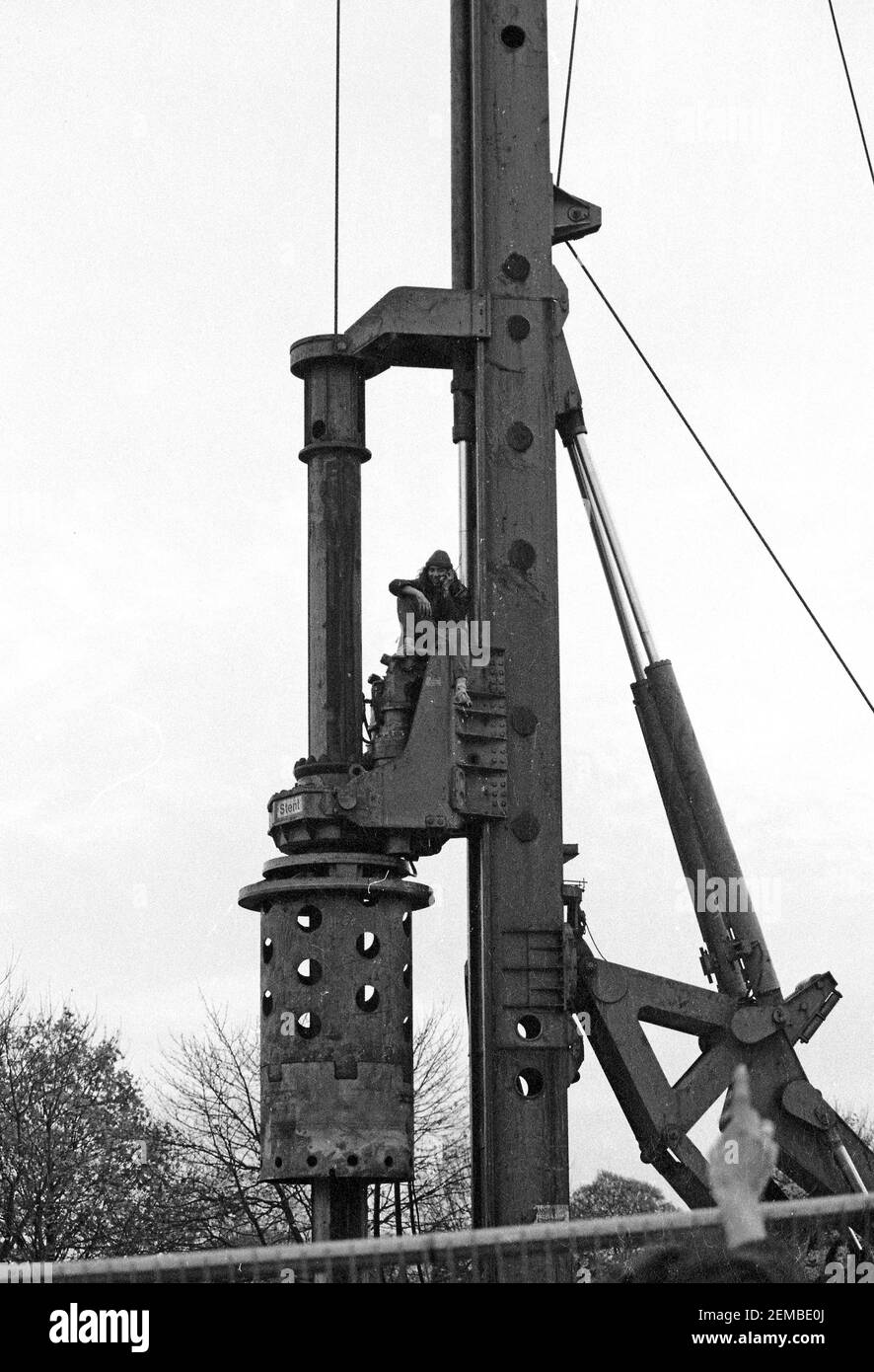 Un manifestant occupant une machine à palplanches sur un chantier de construction dans le cadre des manifestations contre la M11 Link Road à l'est de Londres, 1994 Banque D'Images