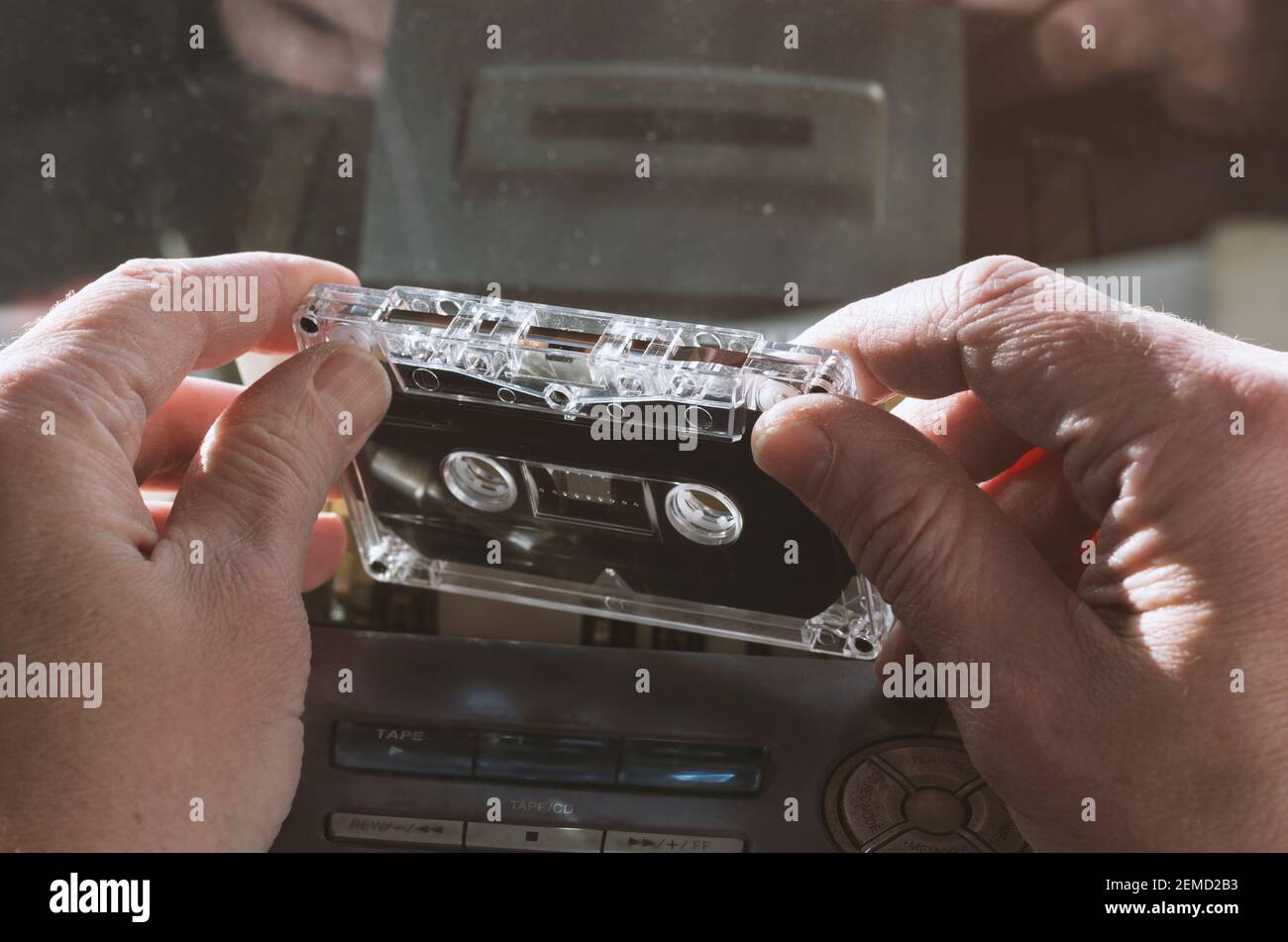 Audiocassette dans les mains des hommes sur le fond d'une cassette enregistreur avec les symboles les plus utilisés sans marque commerciale Banque D'Images