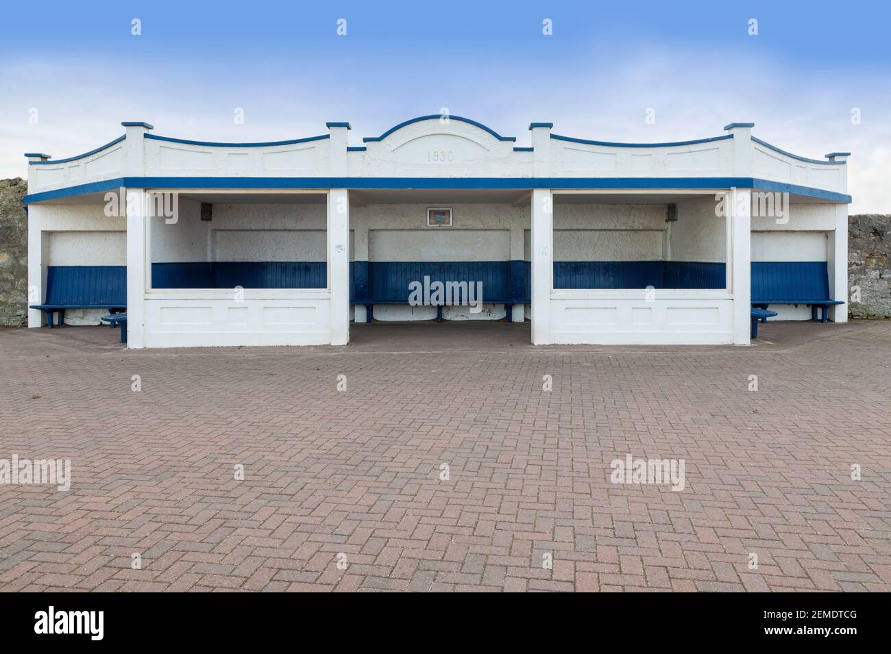 L'abri de plage vide sur la promenade de Spittal, près de Berwick-on-Tweed, daté de 1930, sous un ciel bleu avec un peu de nuages, copier l'espace Banque D'Images
