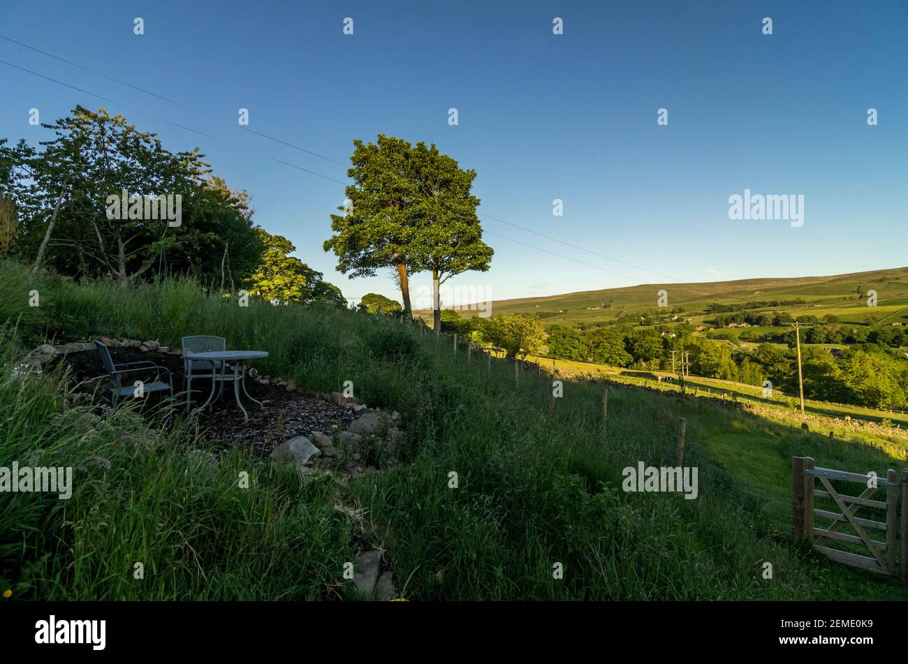 Un coin salon dans un jardin de campagne escarpé, avec le soleil des Pennines du Nord en arrière-plan Banque D'Images