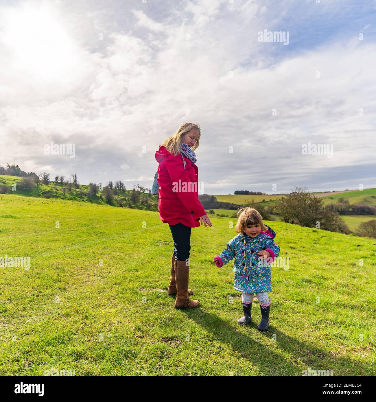 Jeune femme mûre avec un petit enfant souriant heureux appréciant du temps à l'extérieur dans la campagne, au printemps Banque D'Images