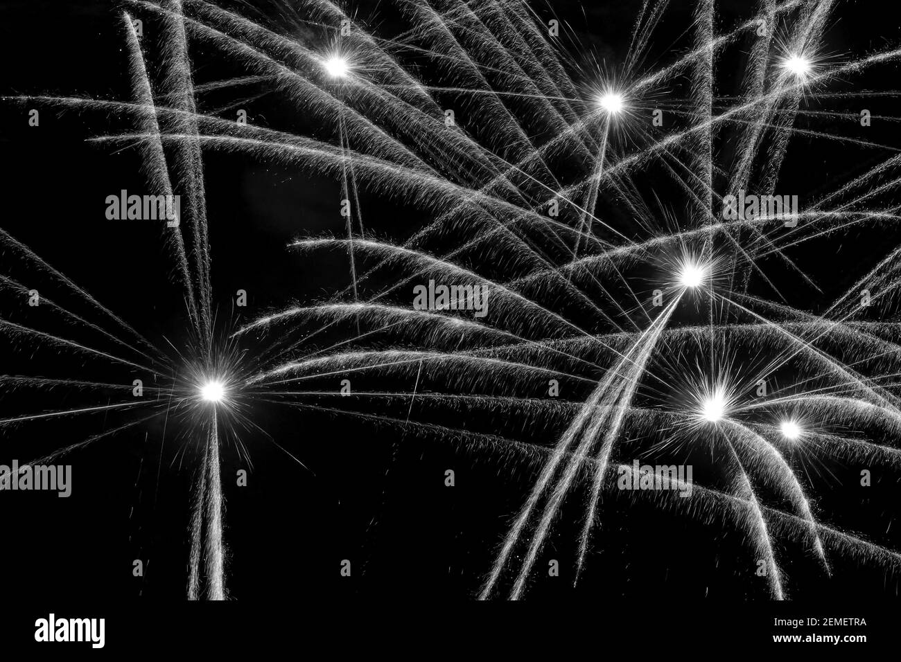 Les feux d'artifice éclairant le ciel sombre ; photo en noir et blanc. Banque D'Images