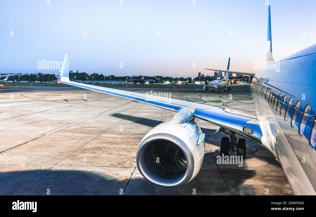 Avion à la porte du terminal prêt pour le décollage à l'heure bleue - aéroport international moderne avec avion d'embarquement la nuit Banque D'Images