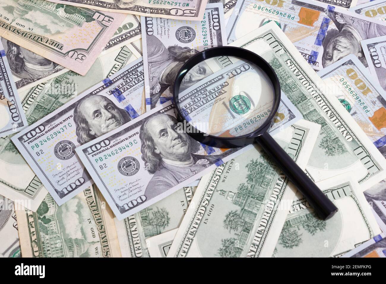 Loupe sur le fond d'un paquet de dollars sur la table gros plan, cent dollars washington, mille - texture, fond Banque D'Images