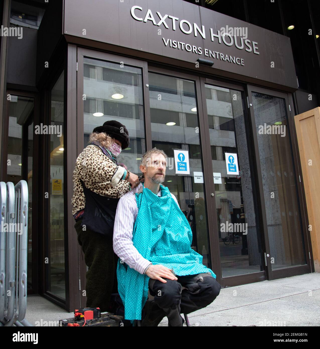 Londres, Royaume-Uni 25 février, 2021 le protestataire anti HS2 et Euston tunneeler Dr Larch Maxey se rasse les cheveux dans les bureaux de HSE. Il proteste contre les risques pris à la fois avec la vie des tunneliers restants par HS2 et avec tout notre avenir par les gouvernements ne pas arrêter l'urgence climatique et nature. Le Dr Maxey a déclaré : « Je n'ai jamais rasé ma tête avant et je ne choisirais pas de perdre mes cheveux, mais je suis terrifié par les rasages de près qui continuent de voir pendant cette éviction. Crédit : Denise Laura Baker/Alay Live News Banque D'Images