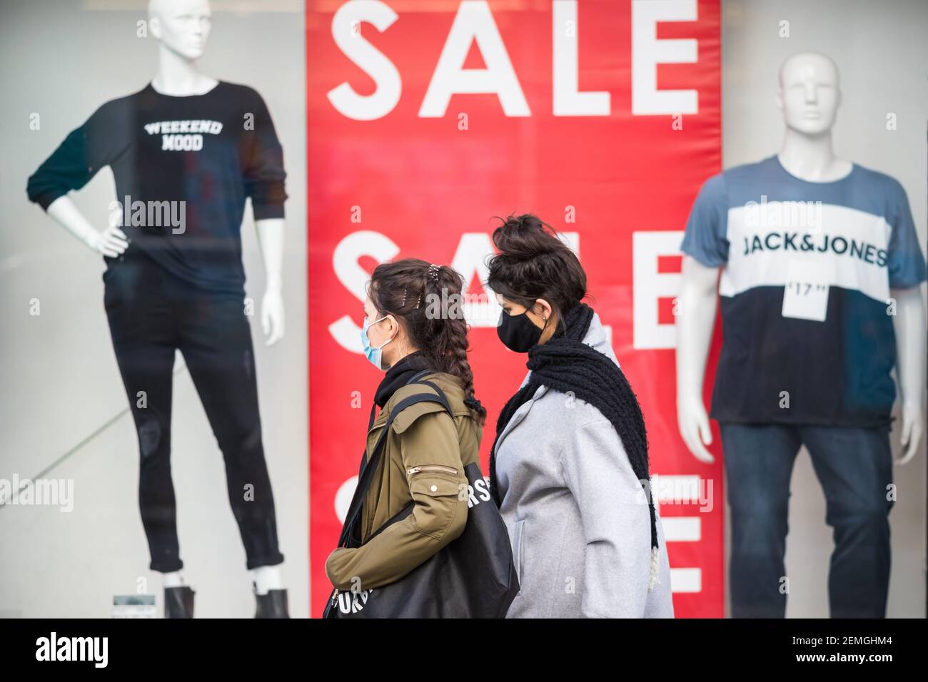 Londres, Royaume-Uni - 5 février, 2021 - personnes avec masque facial protecteur marchant près d'une fenêtre de magasin avec signe de vente sur la rue haute Wood Green Banque D'Images