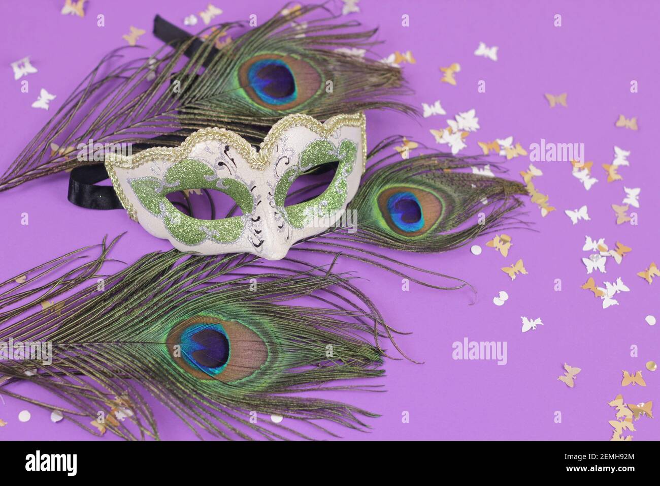 Magnifique carnaval ou Mardi gras masque de venise sur paon plumes fond.décorations de vacances sur fond violet. Banque D'Images