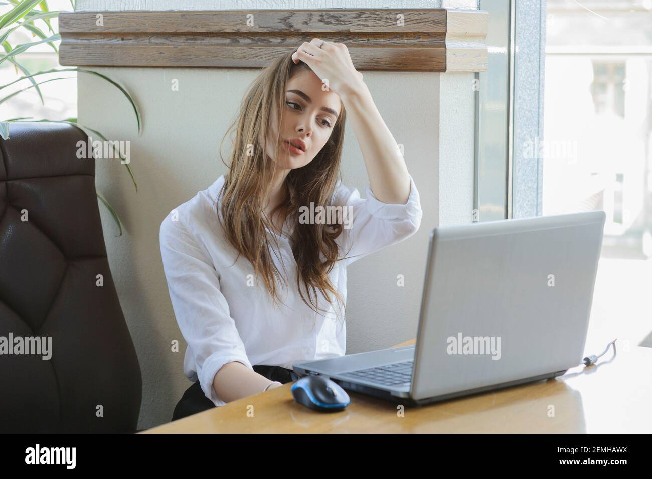 femme travaillant derrière un ordinateur portable près de la fenêtre dans  une atmosphère confortable. Fille dans une chemise blanche et short noir  Photo Stock - Alamy