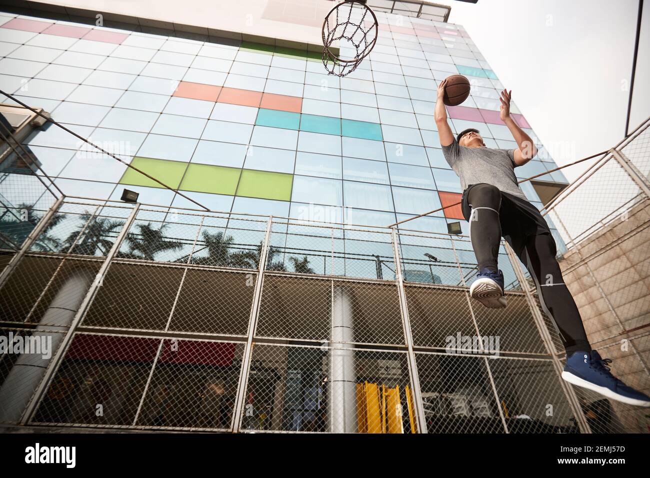 un jeune joueur de basket-ball asiatique va se mettre à pied court extérieur Banque D'Images