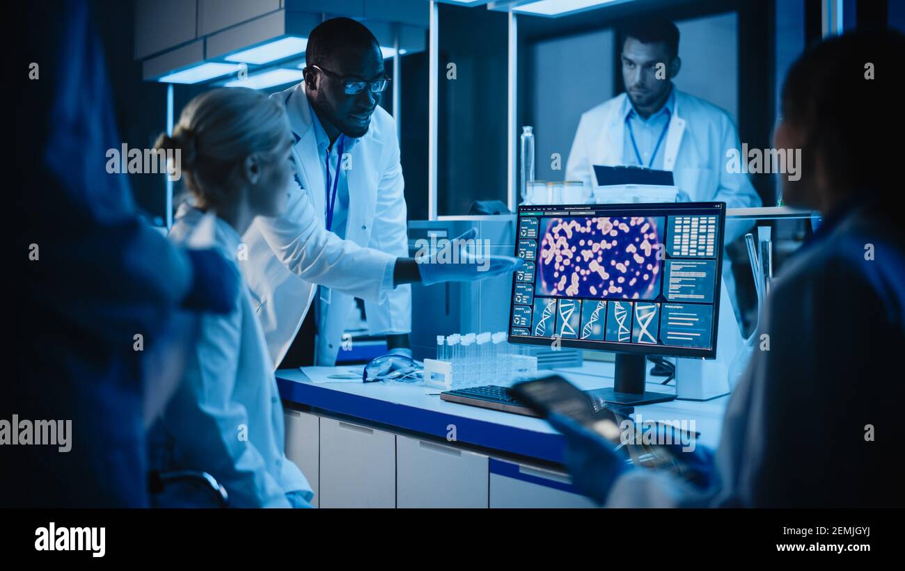 Réunion des laboratoires de recherche médicale : diverses équipes de scientifiques utilisent un ordinateur numérique à tablettes, discutent de la biotechnologie novatrice. Laboratoire avancé pour Banque D'Images